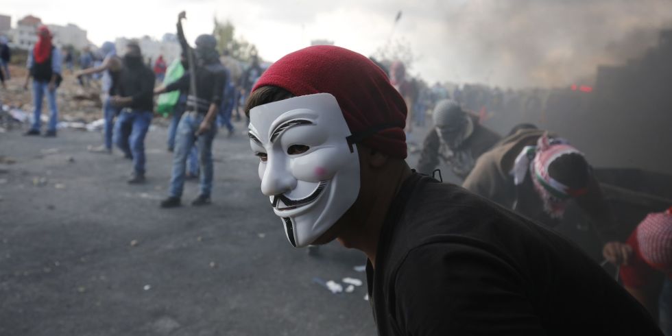 A man at a protest in a Guy Fawkes mask. (photo: Abbas Momani/Getty Images)